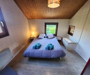 a bedroom with a large bed with two blue pillows at VILLA "Le Jardin" 4 étoiles - Piscine chauffée couloir 12m - Spa Balnéo Hammam - 4 Chambres dont une Love Room de 35m2 avec lit rond, vidéo projecteur Netflix, climatisation in Jardin +14 photos
