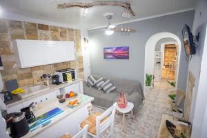 a kitchen and living room with a couch and a table at Anatoli Studios in front of the beach in Mesongi