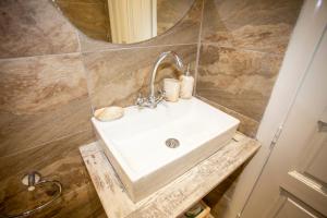 a bathroom with a sink and a mirror at Anatoli Studios in front of the beach in Mesongi +39 photos