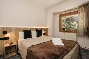 a hotel room with a large bed and a window at La Trobada Hotel Sport in Ripoll