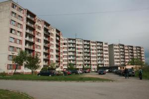 un gran edificio de apartamentos con coches aparcados en un aparcamiento en ŠD Jedlíkova 5 en Košice