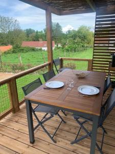 a wooden table and chairs on a wooden deck at Le gîte de la vallée en baie in Mons-Boubert +27 photos
