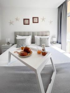 a white table with a plate of food on a bed at Apartment Rocha Varandas Orquídea in Portimão +15 photos
