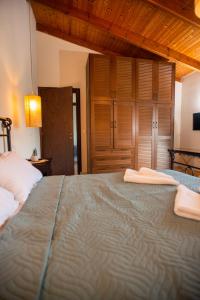a bedroom with a large bed with two towels on it at Alkioni Suites , beachfront, with sea view in Kókkinos Pírgos