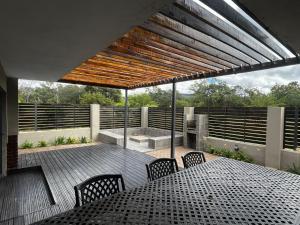 a patio with a table and chairs on a deck at Sasavona Luxury Cottage - 631 Euphoria Golf & Lifestyle Estate in Naboomspruit