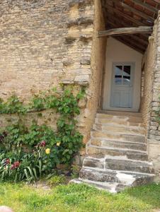 ein Steingebäude mit einer Tür und ein paar Treppen in der Unterkunft Gîte à la ferme in Viserny