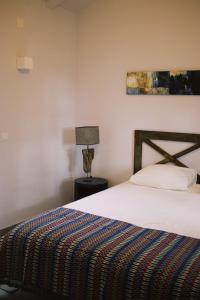 a bedroom with a bed and a lamp on a table at Casa Oliva - Casa da Mata in Porto de Mós
