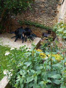 einen Garten mit einer schwarzen Bank und ein paar Blumen in der Unterkunft Gîte à la ferme in Viserny