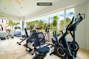 a gym with cardio equipment in a room with a large window at Amazing House with Private Pool - Tennis & Paddle Court in Acapulco