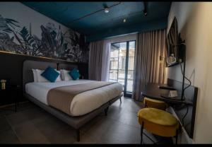 a bedroom with a bed and a desk and a window at Eleven by Warren Collection in Sliema