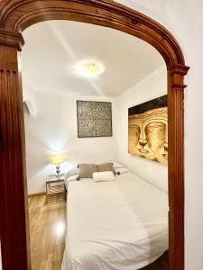 a bedroom with a large white bed with an archway at Borne rooms in Barcelona