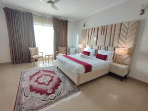 a bedroom with a large bed and a large window at Margalla Hills Residency Islamabad Guest House in Islamabad