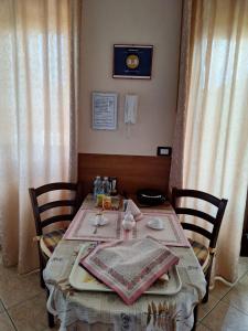 a dining room table with two chairs and a table with at B&B Bertaina Mauro in Cavallermaggiore