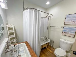 bagno con tenda da doccia bianca e servizi igienici di 1940 Cottage on the Nature Coast a Yankeetown Altre 29 foto