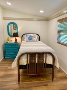 una camera con letto, comò blu e specchio di 1940 Cottage on the Nature Coast a Yankeetown