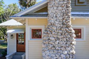 uma casa com uma pilha de troncos ao lado dela em 1940 Cottage on the Nature Coast em Yankeetown