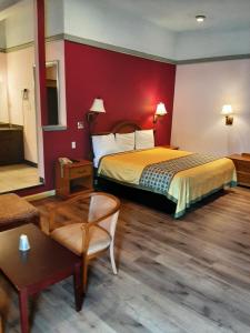 Habitación de hotel con cama con pared roja en Travelers Lodge en Atco