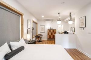 Un dormitorio con una cama blanca y una cocina. en Steps to Bathhouses, Historic Studio, KING BED, Room # 101, en Hot Springs