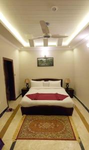 1 dormitorio con 1 cama y ventilador de techo en Triple One Hotel Suites en Abbottabad