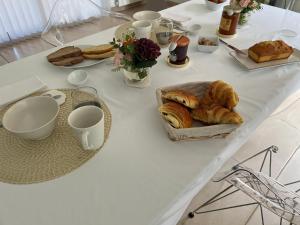 - une table blanche avec du pain et des viennoiseries dans l'établissement LA VILLA DIANE, à Montauban