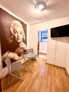 a living room with a table and a painting of a woman at Borne rooms in Barcelona