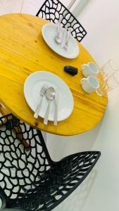 una mesa de madera con platos y utensilios. en Fortal Flat, en Fortaleza