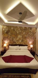 a bedroom with a large bed with a ceiling fan at Triple One Hotel Suites in Abbottabad