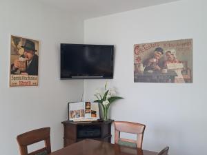 a dining room with a table and a flat screen tv at B&B DA ROBERTINO in Tricesimo