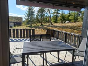 a porch with a wooden table and benches on a deck at Perfect location at Lifjell in Lifjell