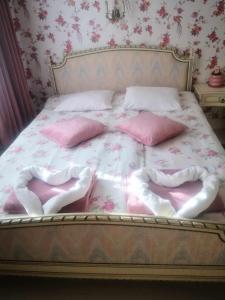 a bed with pink and white sheets and pillows at Raudtee in Viljandi