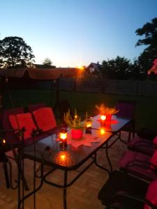a patio with a table with candles and chairs at Raudtee in Viljandi