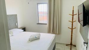 1 dormitorio con 1 cama con 2 toallas en Fortal Flat en Fortaleza