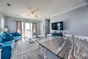 een woonkamer met een tafel en een blauwe bank bij Emerald Isle, Ocean Views with Pool and Beach Access in Emerald Isle +25 foto's
