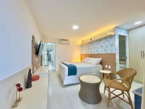 a hotel room with a bed and a table and chairs at Golf Ville Resort - Porto das Dunas in Aquiraz +181 photos