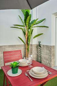 czerwony stół z talerzami i kieliszkami do wina w obiekcie Studio Novena Little Apartments w Kadyksie