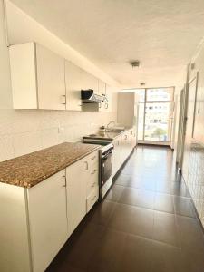 a kitchen with white cabinets and a tile floor at ItsaHome Aparments - Casa del Parque in Quito