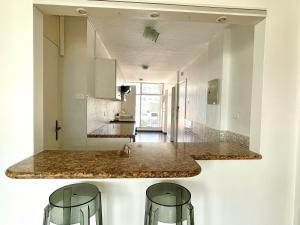 a kitchen with a marble counter top and two stools at ItsaHome Aparments - Casa del Parque in Quito