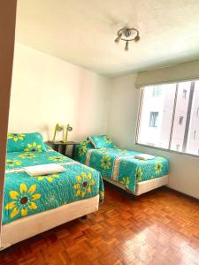 a bedroom with two beds and a window at ItsaHome Aparments - Casa del Parque in Quito