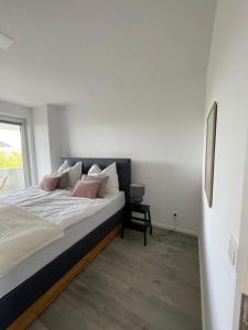 - une chambre avec un lit doté d'oreillers roses et d'une fenêtre dans l'établissement Penthouse Langenloiserberg, à Krems an der Donau