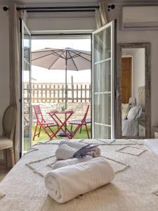 1 dormitorio con 1 cama con sombrilla y mesa en Studio Novena Little Apartments, en Cádiz