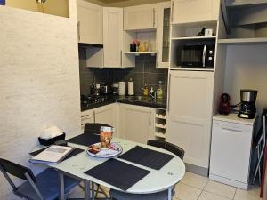 a small kitchen with a table and a table and chairs at Le Saint Julien in Le Tréport
