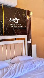 Una cama con un cartel que lee campamentos de lujo del ejército en RUM ATANA lUXURY CAMP en Wadi Rum