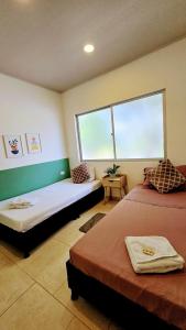 Cette chambre comprend 2 lits et une fenêtre. dans l'établissement Finca acogedora en Villeta con piscina privada, à Villeta