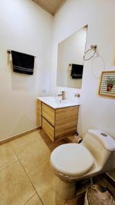 a bathroom with a toilet and a sink and a mirror at Finca acogedora en Villeta con piscina privada in Villeta