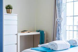1 dormitorio con escritorio y 1 cama con toallas en Villa Marzella - Luxury Costa Adeje, en Adeje