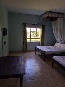 Habitación grande con 2 camas y ventana. en MUSEUM VIEW HOTEL KISUMU CITY-MILIMANI en Kisumu