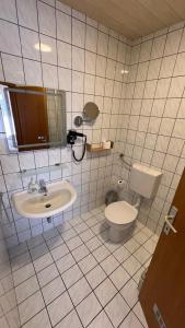 a white tiled bathroom with a toilet and a sink at Vila Park Turanj in Turanj +49 photos