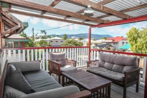 a porch with two chairs and a couch and a table at Ryan's Rest Boutique Accommodation in Cairns