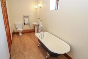 a bathroom with a tub and a toilet and a sink at The Granary in Penzance +24 photos