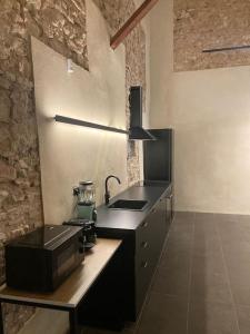 a kitchen with a black counter and a sink at Amazing suite by the fair in Valencia